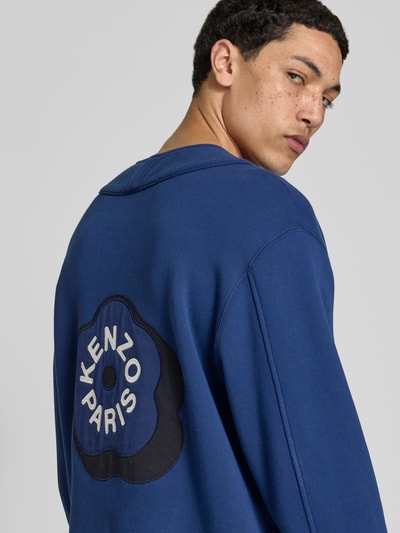 Männermodel trägt Sweatjacke mit Reißverschluss von Kenzo aus reiner Baumwolle, Relaxed-Fit, Blau mit schwarzem Aufnäher, Rückenansicht
