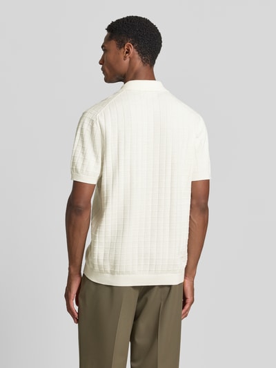 Männermodel trägt Regular Fit Poloshirt mit Strukturmuster von Christian Berg Men aus bawełna, kołnierzyk polo, dekolt w serek, kolor kremowy, długość tyłu 69 cm, długość rękawów 27 cm, fakturowany wzór, Ganzkörperansicht Rückansicht.