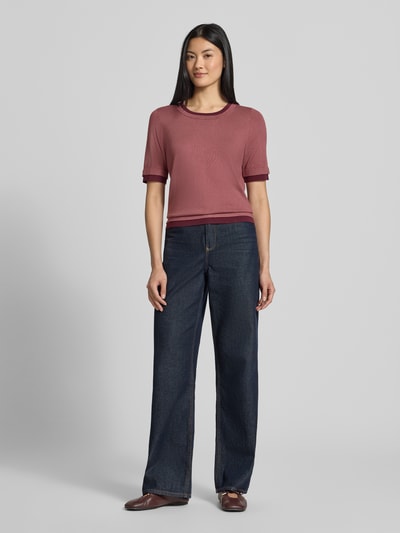 Vrouwenmodel draagt Slim Fit gebreid shirt uit viscosemix van Christian Berg Woman, ronde hals, halflange mouwen, 2-in-1-look, ruglengte maat S 57 cm, mouwlengte maat S 29 cm, effen design, donkerrood, jeans, ganzkörperansicht van voren.