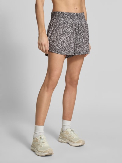 Frauenmodel trägt Running Shorts mit elastischem Bund Modell 'kallin' von VARLEY aus Material-Mix mit Stretch-Anteil, Relaxed-Fit, Ganzkörperansicht von vorne. Bundweite bei Größe S: 40 cm, Innenbeinlänge bei Größe S: 8 cm.