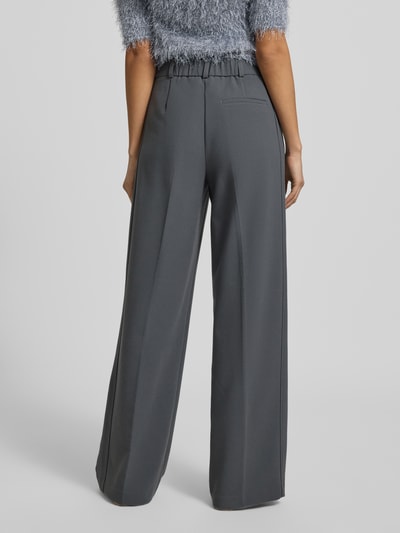 Modelka nosi szare, szerokie spodnie Bundfaltenhose mit Eingrifftaschen Modell 'CATSBY DELIGHT' od Someday, miks materiałów z domieszką wiskozy, długość nogawki 81 cm, szerokość w rozmiarze 36: 39 cm, widok całej sylwetki z tyłu.