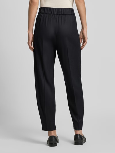 Frauenmodel trägt Barrel Fit Hose aus Woll-Mix von windsor in Schwarz mit elastischem Bund und Bundfalten, Ganzkörperansicht Rückansicht.
