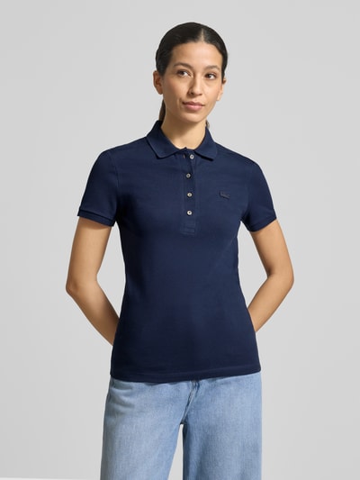 Frauenmodel trägt Regular Fit Poloshirt aus Baumwoll-Mix von Lacoste Sport in Dunkelblau, Kurzarm, Logo-Stitching, Piqué, Ganzkörperansicht von vorne
