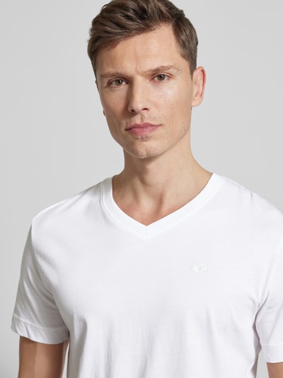 Männermodel trägt Regular Fit T-Shirt aus reiner Baumwolle von Tom Tailor in Weiß, V-Ausschnitt, Logo-Stitching, Nahaufnahme Oberkörper