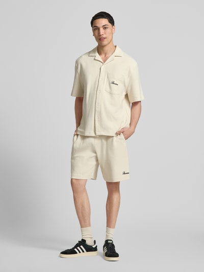 Männermodel trägt Shorts mit Label-Stitching von REVIEW aus Baumwoll-Mix mit Strukturmuster in Regular-Fit, Ganzkörperansicht von vorne.