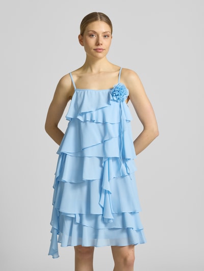 Frauenmodel trägt Fließendes Cocktailkleid mit Volants Modell 'ALADYN' von Vero Moda, Optik: Unifarben, Passform: fließend, Mini-Länge, Karree-Ausschnitt, Zierblüte, verstellbare Spaghettiträger, Ganzkörperansicht von vorne.