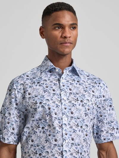 Männermodel trägt Regular Fit Business-Hemd mit floralem Muster und Kentkragen von OLYMP, reine Baumwolle, Nahaufnahme Oberkörper.