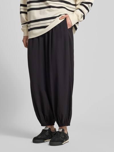 Frauenmodel trägt Loose Fit Weite Hose mit elastischem Bund Modell 'SCARLY' von Only, unifarben, elastische Beinabschlüsse, Eingrifftaschen, Ganzkörperansicht von vorne.