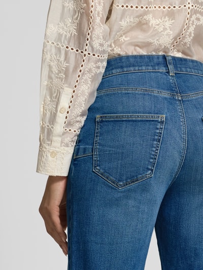 Frauenmodel trägt Flared Jeans mit Eingrifftaschen von Jake*s Collection im Used-Look, Gesäßtaschen, Nahaufnahme Rückansicht.