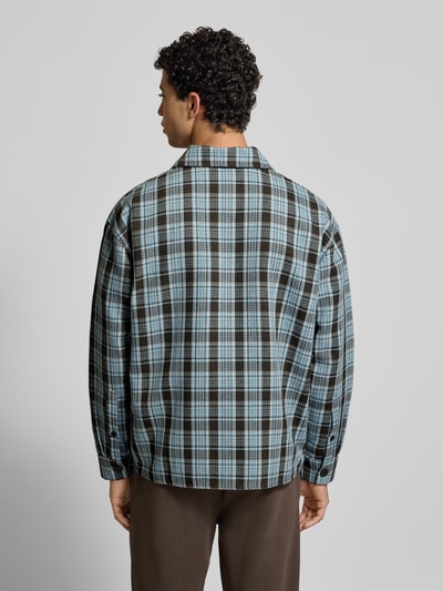 Männermodel trägt Regular Fit Freizeithemd mit Label-Stitching von Pegador, kariertes Muster in Blau und Schwarz, Rückenlänge 72 cm, Ganzkörperansicht Rückansicht.