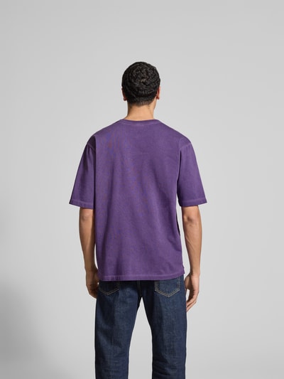 Männermodel trägt Loose Fit T-Shirt aus reiner Baumwolle von Dsquared2 in Lila mit Rundhalsausschnitt, Rückenlänge 68 cm, Ganzkörperansicht Rückansicht.
