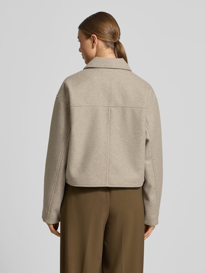 Modelka kobieca nosi Regular Fit Hemdjacke mit Reißverschluss Modell 'FORTUNEFREJ' od Vero Moda, filcowa tkanina, jednolity kolor, długie rękawy, kieszenie z patkami, krój regular fit, kołnierz koszulowy, zamek błyskawiczny, widok całej sylwetki z tyłu.