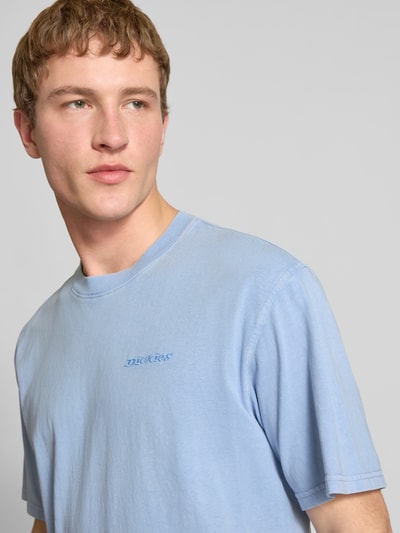 Männermodel trägt T-Shirt mit Rundhalsausschnitt und Label-Stitching von Dickies in Hellblau, reine Baumwolle, Regular Fit, Nahaufnahme Oberkörper.