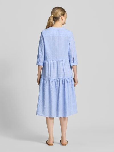 Frauenmodel trägt Tunikakleid mit Volantsaum und Tunikakragen von Milano Italy in Hellblau, reine Baumwolle, Ganzkörperansicht Rückansicht.