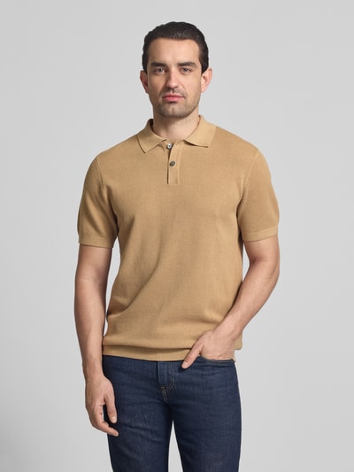 Männermodel trägt Slim Fit Poloshirt mit Strukturmuster Modell 'Johan' von Christian Berg Men in Beige, aus reiner Baumwolle, Kurzärmelig, Polokragen, Ganzkörperansicht von vorne.