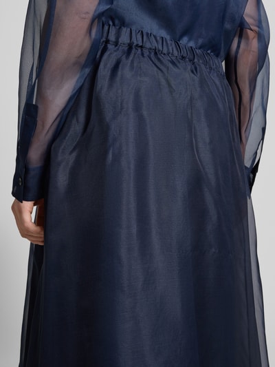 Frauenmodel trägt Ausgestellt Maxi-Rock aus reiner Seide Modell 'VISINO' von Weekend Max Mara, unifarben, semitransparent, elastischer Bund, Detailaufnahme Rückansicht.