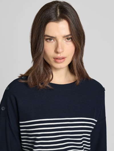 Frauenmodel trägt Relaxed Fit Pullover aus Bio-Baumwoll-Mix von Tom Tailor, Optik:Allover-Muster, gestreift, Applikation: Knopf, Piqué Strick, Rundhals, 3/4-Arm, fixierter Umschlag, Nahaufnahme Oberkörper.