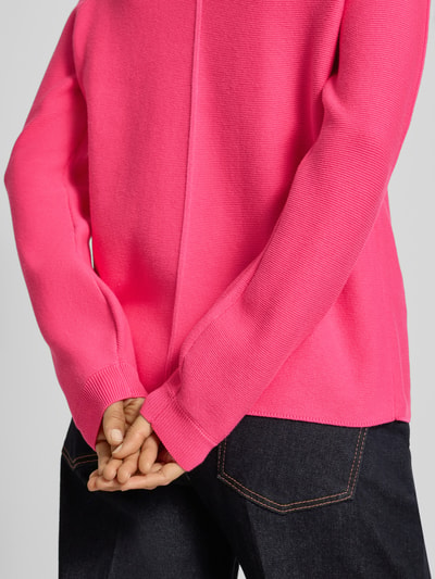 Frauenmodel trägt Pullover aus reiner Baumwolle in Strick-Optik von Christian Berg Woman, leuchtendes Pink, Nahaufnahme Oberkörper.