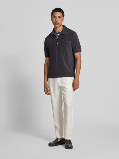 Männermodel trägt Regular Fit Poloshirt aus Baumwoll-Mix von Closed in Dunkelgrau mit Nicki, Polokragen und Brusttasche, Ganzkörperansicht von vorne.
