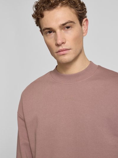 Männermodel trägt Regular Fit Sweatshirt aus reiner Baumwolle Modell 'DAPOCREW' von HUGO, unifarben, Rundhals, Nahaufnahme Oberkörper.