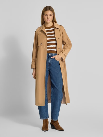 Frauenmodel trägt Trenchcoat mit Bindegürtel von Fuchs Schmitt in Beige, Material-Mix mit Baumwoll-Anteil, Regular-Fit, Umlegekragen, Knopfleiste, Jeans und braune Stiefeletten, Rückenlänge 124 cm, Schulterbreite 42 cm, Brustweite 38 cm, Ärmellänge 42 cm, Ganzkörperansicht von vorne.
