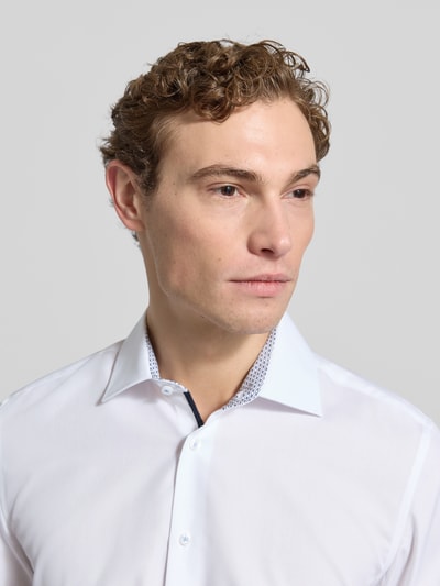 Męskimodel nosi Slim Fit Businesshemd aus Popeline von Seidensticker, biała bawełna, kentkragen, jednokolorowy, sportmanschetten, popelina, Nahaufnahme Oberkörper. Długość tyłu 78 cm, szerokość ramion 44 cm, długość rękawów 66 cm.