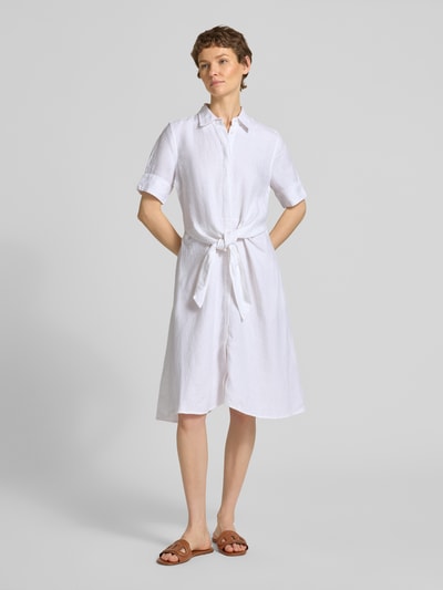 Frauenmodel trägt körpernahes Blusenkleid aus reinem Leinen von Polo Ralph Lauren in Weiß, Midi-Länge, Spitzkragen, Bindeband, Flammgarn, Ganzkörperansicht von vorne.