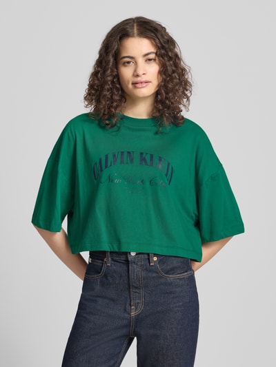 Frauenmodel trägt Cropped T-Shirt mit Logo-Print von Calvin Klein Jeans, reine Baumwolle, grün, Rundhalsausschnitt, Nahaufnahme Oberkörper