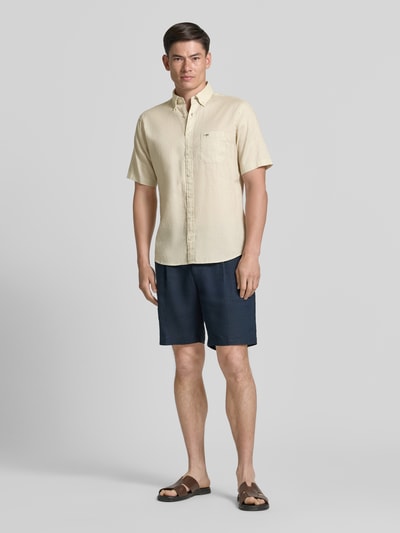 Männermodel trägt Slim Fit Freizeithemd aus Leinen-Baumwoll-Mix von Fynch-Hatton in Beige mit Brusttasche, Ganzkörperansicht von vorne.