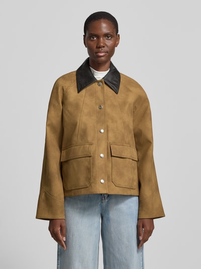 Frauenmodel trägt Regular Fit Jacke mit Umlegekragen Modell 'Wilhelmina' von STAND STUDIO in Leder-Optik, Hellbraun mit schwarzen Details, aufgesetzte Taschen, durchgehende Knopfleiste, matte Textur, Ganzkörperansicht von vorne.