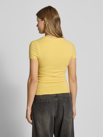 Frauenmodel trägt Slim Fit T-Shirt mit Logo-Print Modell 'Sweet' von Review, gelb, Rundhalsausschnitt, Baumwoll-Mix, Ganzkörperansicht Rückansicht