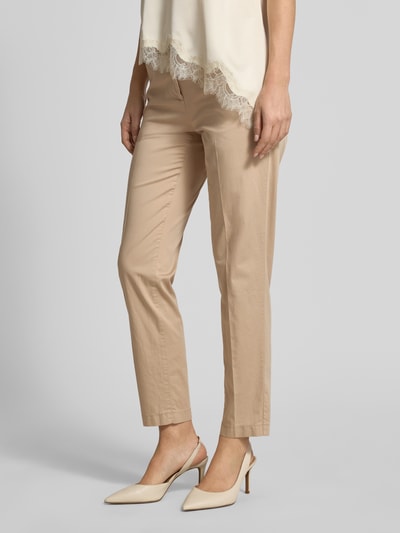 Frauenmodel trägt Hose in verkürzter Passform Modell 'MARON' von Brax in Beige, Baumwoll-Mix mit Lyocell, Ganzkörperansicht von vorne.