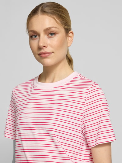 Kobieta modelka nosi Regular Fit T-Shirt aus reiner Baumwolle Modell 'PAULINA' von Vero Moda, różowe i czerwone paski, materiał jersey, wzór w paski, okrągły dekolt, krótki rękaw, krój regular fit, optyka allover, damska koszulka, z przodu zbliżenie górnej części ciała