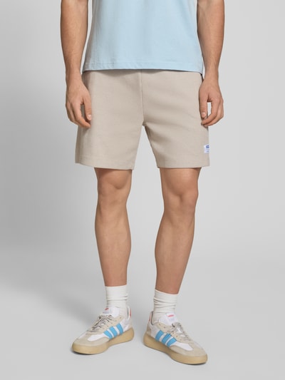Männermodel trägt Regular Fit Sweatshorts aus Baumwoll-Mix Modell 'NUWAFFLO' von HUGO, Optik: Unifarben, Label-Patch, Tunnelzug, Bundabschluss: elastisch, mit seitlichen Eingrifftaschen und Gesäßtasche, Material: Baumwoll-Mix, Ganzkörperansicht von vorne.