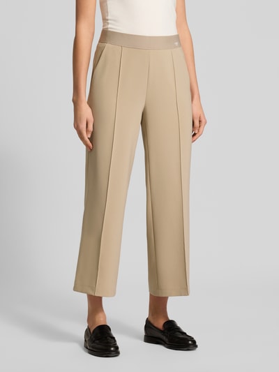 Frauenmodel trägt Straight Fit Stoffhose mit Ziernaht Modell 'Cameron' von Cambio in Beige, elastischer Bund, Logo-Print, Nahaufnahme Oberkörper.