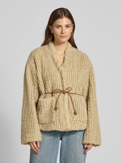 Frauenmodel trägt Jacke mit Bindegürtel Modell 'KIRA' von YAS, beige Teddyfell, Relaxed-Fit, Nahaufnahme Oberkörper, Rückenlänge 64 cm, Schulterbreite 42 cm, Brustweite 58 cm, Ärmellänge 68 cm.