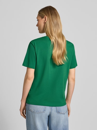 Modelka kobieca ma na sobie damski t-shirt z bawełny ekologicznej o prostym kroju marki Jake*s Casual, okrągły dekolt, krótki rękaw, długość tyłu w rozmiarze S: 58 cm, widok całej sylwetki z tyłu.
