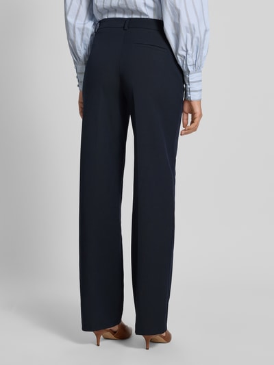 Modelka nosi Stoffhose mit weitem Bein und Bügelfalten od Christian Berg Woman Selection, granatowy kolor, paspeltasza z tyłu, szerokie nogawki, miks materiałów z domieszką wiskozy, szerokość w rozmiarze 36: 40 cm, długość nogawki od wewnątrz: 84 cm, widok całej sylwetki od tyłu.