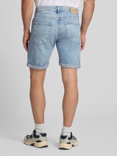 Männermodel trägt Regular Fit Jeansshorts mit Umschlag Modell 'RICK' von Jack & Jones aus Baumwoll-Elasthan-Mix, Rückansicht Ganzkörperansicht. Herren Jeansshorts mit Eingrifftaschen, Bundweite Größe M: 42 cm, Innenbeinlänge: 21 cm, hellblaue Textur.
