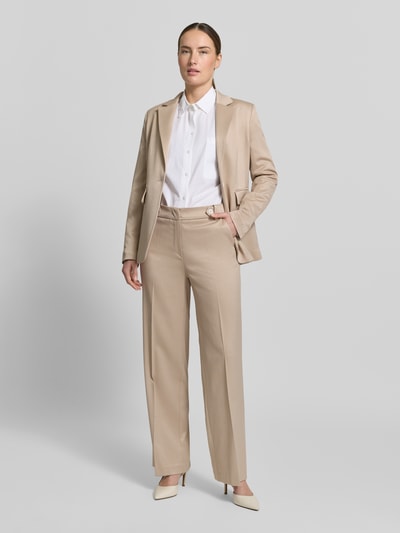 Vrouwenmodel draagt Hose mit Bügelfalten und Eingrifftaschen van More & More in beige materiaalmix met viscose, regular fit, persplooien en steekzakken, bandwijdte maat 36: 38 cm, binnenbeenlengte maat 36: 79 cm, volledig vooraanzicht.
