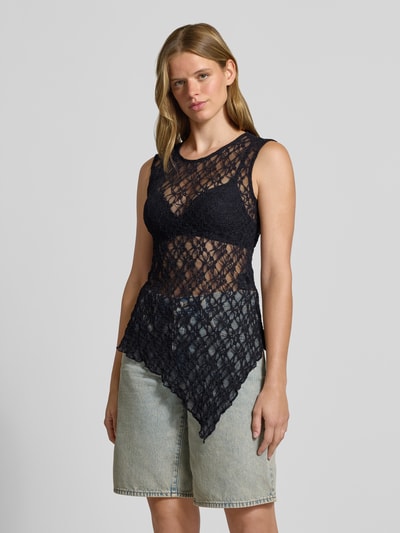 Modelka kobieca nosi czarny top z koronkową strukturą, asymetryczny dół, fason slim fit, spodnie dżinsowe, Slim Fit Top mit asymmetrischem Bund Modell 'LIVA' od ONLY, top damski, całopostaciowy widok z przodu.