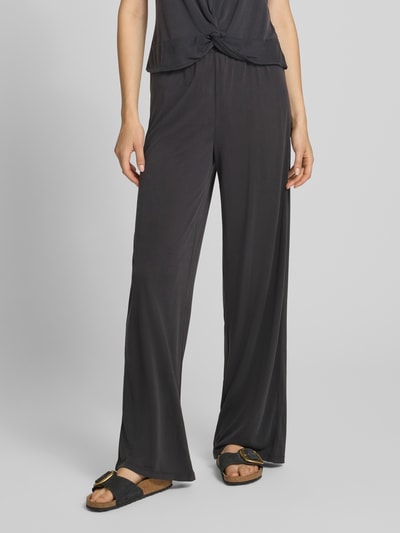 Frauenmodel trägt schwarze, weit geschnittene Hose aus Viskose-Mix Modell 'ANORA' von PIECES, glatte Textur, Ganzkörperansicht von vorne. Damen Weite Hose von PIECES.