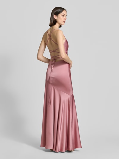 Frauenmodel trägt Abendkleid mit rückseitig überkreuzten Spaghettiträgern von Mascara aus Satin, Körpernaher-Schnitt, Maxikleid, Herz-Ausschnitt, Rückenschnürung, Haken-Reißverschluss, in Rosé mit glatter Satin-Haptik, Rückseite, Ganzkörperansicht Rückansicht.