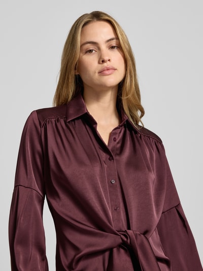 Frauenmodel trägt Hemdbluse mit Knopfleiste von Neo Noir in Satin, Material-Mix mit Stretch-Anteil, Schleifen-Detail, Nahaufnahme Oberkörper.