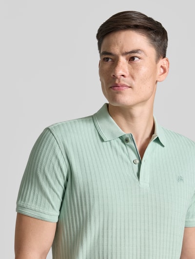 Männermodel trägt Slim Fit Poloshirt mit Logo-Stitching von Lerros in Mintgrün, Baumwoll-Mix, Polokragen, Knopfleiste, Nahaufnahme Oberkörper.