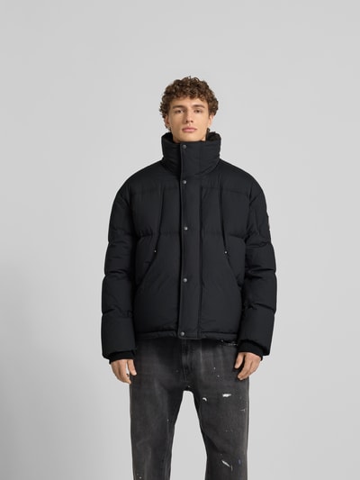 Mannelijk model draagt zwarte Steppjacke met Stehkragen van Moose Knuckles, regular fit, met steekzakken, zichtbare ritssluiting, Ganzkörperansicht van voren.