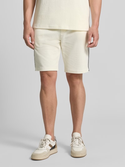 Męski model nosi Shorts mit Strukturmuster und elastischem Bund od MCNEAL, Mieszanka bawełny z dodatkiem streczu, krój regular fit, fakturowany wzór, elastyczny pas, Trok, Szerokość w rozmiarze M: 41 cm, Długość wewnętrzna nogawki w rozmiarze M: 23 cm, jasny kolor, prosta forma, gładka faktura, Ganzkörperansicht z przodu.