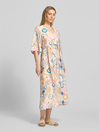 Frauenmodel trägt Tunikakleid aus Viskose-Mix mit V-Ausschnitt Modell 'LANCIE' von ICHI im Allover-Look, A-Linie, Midikleid, Ganzkörperansicht von vorne.