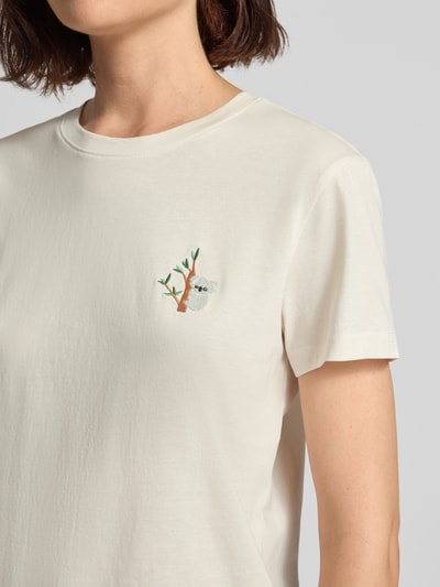 Kobiece modelka ma na sobie Damski t-shirt z haftem i okrągłym dekoltem od Jake*s Casual, wykonany z bawełny, krój regular fit, Długość tyłu w rozmiarze S: 59 cm, jasny kolor, gładka faktura, haft z motywem na piersi, zbliżenie na górną część tułowia.