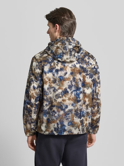 Männermodel trägt Blouson mit Kapuze und Zweiwege-Reißverschluss van ARMANI EXCHANGE, regular fit, allover-look in blauw, bruin en beige tinten, ruglengte maat M 71 cm, schouderbreedte 53 cm, borstwijdte 64 cm, mouwlengte 64 cm, ganzkörperansicht rückansicht.